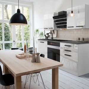 Cucina bianco-nera luminosa con tavolo in legno chiaro
